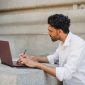 Seorang pencari kerja sedang mengedit dokumen resume digital di laptop untuk disesuaikan dengan kriteria sistem pelacak pelamar otomatis.