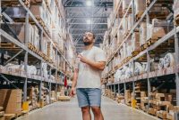 Para pekerja pergudangan sedang memilah dan menyiapkan paket pesanan di pusat logistik modern untuk memastikan kelancaran rantai pasokan produk ke seluruh wilayah.