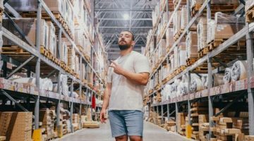 Para pekerja pergudangan sedang memilah dan menyiapkan paket pesanan di pusat logistik modern untuk memastikan kelancaran rantai pasokan produk ke seluruh wilayah.