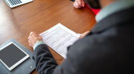 Seorang pencari kerja sedang mengurasi dokumen resume dan portofolio digitalnya secara cermat sebelum mengunggahnya ke portal lowongan kerja.