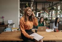 Para profesional muda sedang berdiskusi merencanakan strategi bisnis di sebuah ruang kerja modern yang kolaboratif dan dinamis.