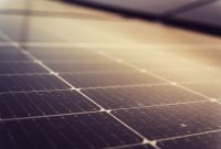 Para profesional muda berdiskusi mengenai proyek energi terbarukan dan pengembangan teknologi hijau di sebuah ruang kerja modern.